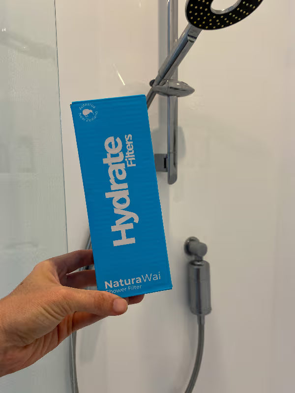 Image of hand holding shower filter box in bathroom